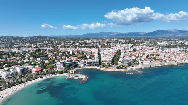 Aerial view of Antibes' buildings nestled along the coast, where the turquoise sea meets the ochre architecture, Antibes, France.