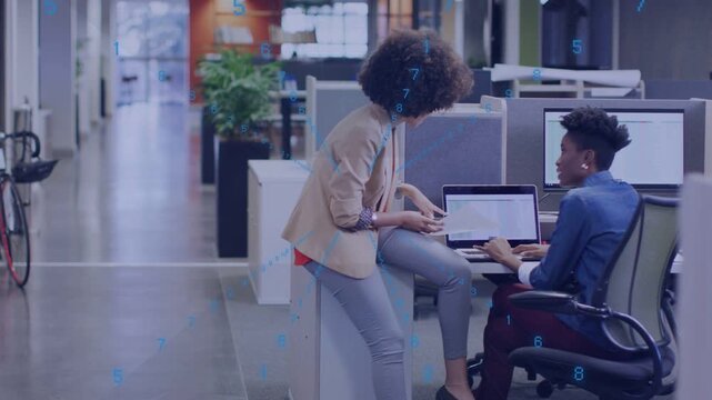 Standing woman showing report on laptop starting seated peer typing and sharing chart for business