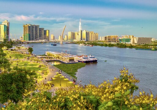 Aerial view of a vibrant city skyline reflecting in the tranquil river, with modern architecture and lush greenery creating a harmonious contrast, Ho Chi Minh City, Vietnam.