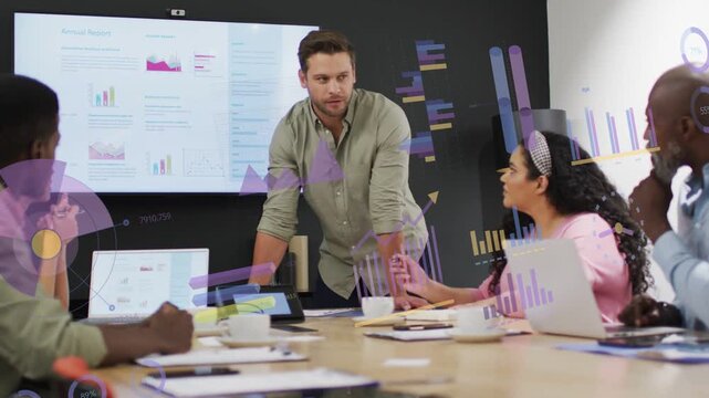 Manager leaning and gesturing at screen, making live charts appear over table for business review