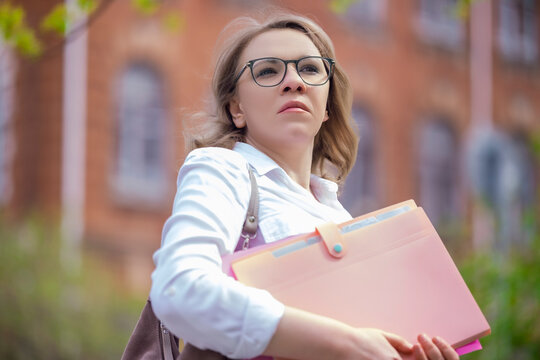 Professional woman director in glasses with folders. Corporate vision and business leadership.