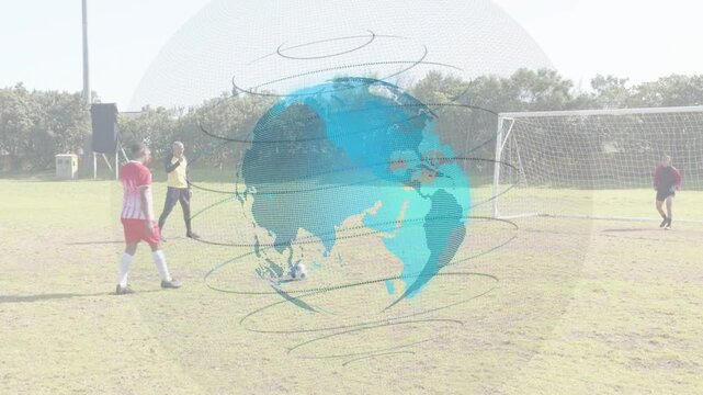 Soccer player placing, striking ball for goal as GK dives player down ref standing globe overlay