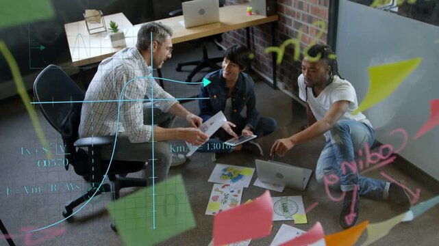 Man leaning forward presenting printout, design team rearranging mockups, finalizing branding