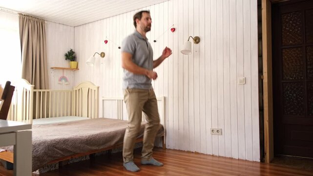 Handsome bearded man dance, have fun at home listens song, moves to music, feels overjoyed, celebrate good news, relish carefree life looks happy. Young adult male twirls, grooves, dancing in kitchen