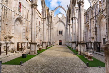 Obraz premium Historic ruins of Carmo Convent in Lisbon featuring gothic arches, stone columns and open roof courtyard, showcasing medieval architecture and cultural heritage in Portugal.