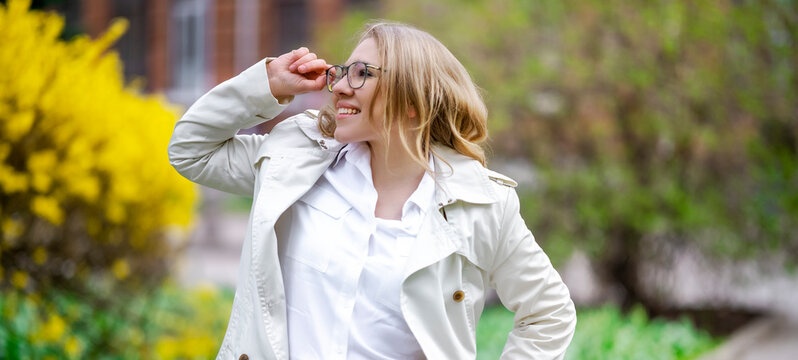 Woman looking up with glasses outdoors. Spring sunlight and happy lifestyle inspiration.