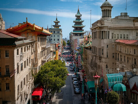 Panoramic view of historic medieval architecture and ancient stone buildings lining a narrow street in the old town of Segovia, Spain, featuring a classic European church tower against the sky