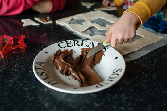 Little child's hand scraping chocolate spread with knife