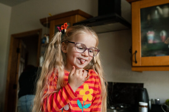 Child happy after licking chocolate spread and pulling her tongue out