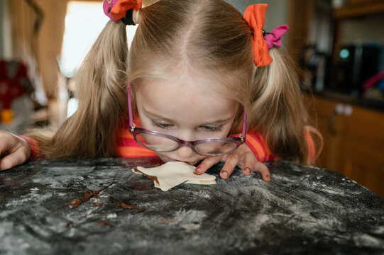 Child with glasses tasting chocolate spread off directly from the table