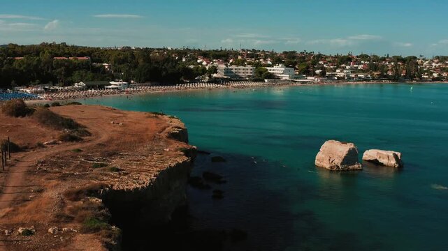 Panoramic overview of Fontana Bianca Sicilian beach nestled below dramatic sea cliffs
