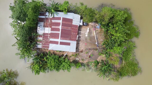 Aerial view of lone house surrounded by floodwater at village in sylhet haor.