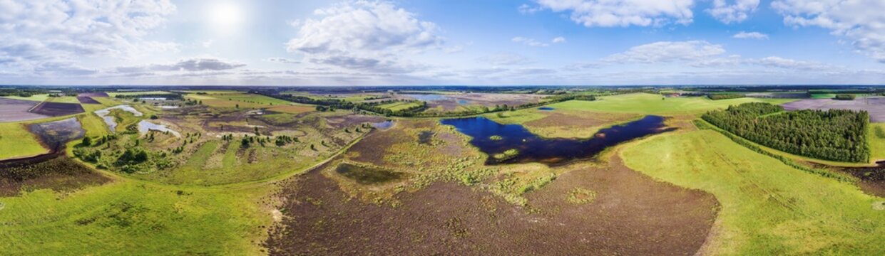 Aerial view of newly created nature reserve with wetlands, heather, grassland, lakes and trees between cropland, in 360 degrees panorama, Scharreveld, Drenthe, Netherlands.