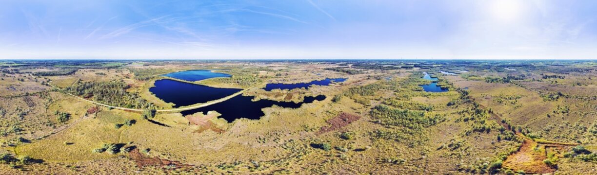 Aerial view of wetland with lakes, heather, trees, ferns and marshes in raised bog area, in 360 degrees panorama, national park De Groote Peel, border of Noord-Brabant and Limburg, Netherlands.
