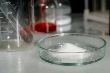 In a laboratory, a researcher analyzes a white powder during a scientific experiment. © Michael
