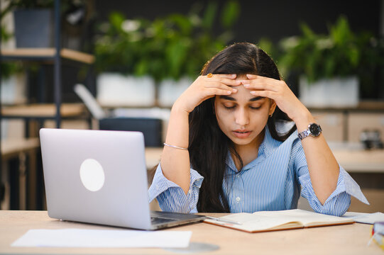 Indian student feeling headache from stress while studying