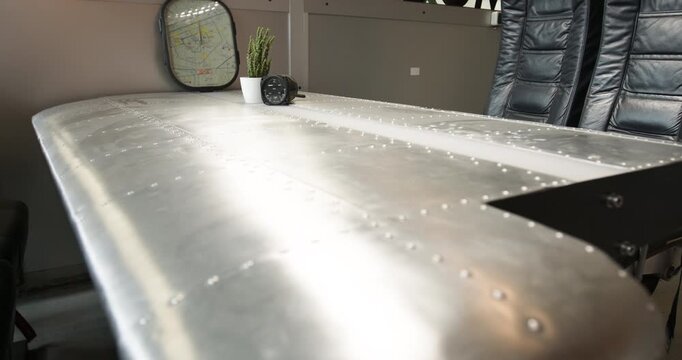 View from inside a commercial aircraft fuselage showing the exposed metal structural frames and windows