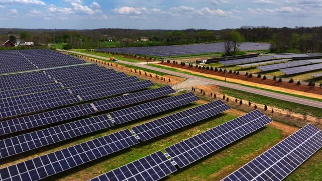 Aerial view of rows of solar panels creating a geometric landscape with a road nearby, symbolizing renewable energy, Lebanon, Ohio, United States.