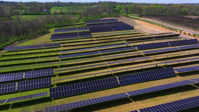 Aerial view of vast solar panel array contrasting with the green trees, showcasing renewable energy infrastructure, Lebanon, Ohio, United States.