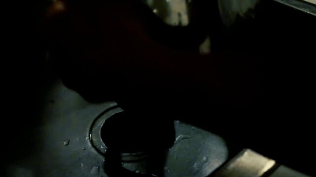 Hand washing kitchen strainer under sink water with drain close up domestic cleaning routine