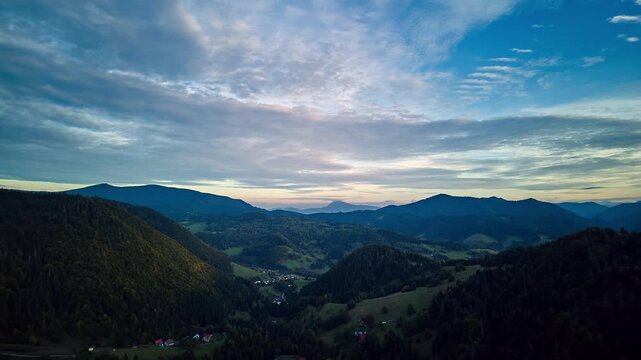 Aerial hyperlapse of sunset over rural mountain valley and autumn forest