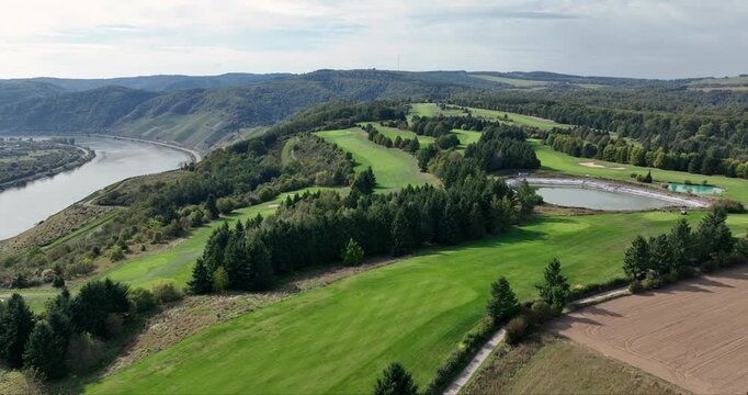 Aerial view of the Golfclub Jakobsberg, with its lush green fairways, tranquil ponds, and the meandering river in the distance, Braubach, Germany.