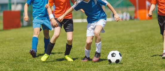 Fototapeta premium Youth Soccer Match Duel. Kids Competing for Ball During Outdoor Football Game Action