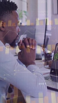 Vertical video: Analyst watching laptop, business update sparking moving chart overlays, studying