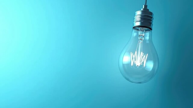 Hanging light bulb against blue background with visible filament