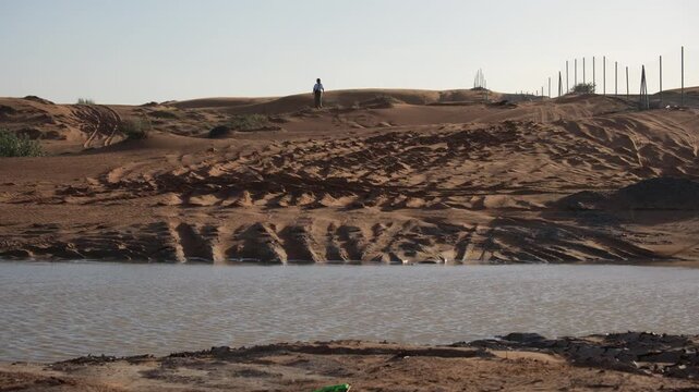 Female tourist walking on sand dunes in UAE wilderness landscape