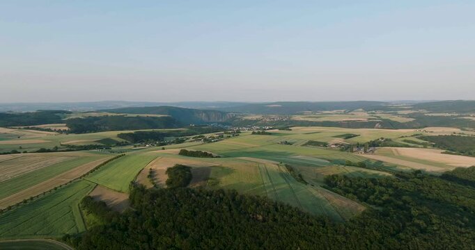 Aerial view of lush green fields contrasting with dark forests, creating a patchwork quilt effect over the landscape, Dieblich, Germany.