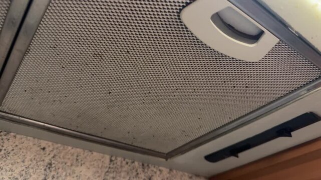 Closeup Metal Range Hood Filters Showing Stainless Mesh Panels, Removable Handles And Speckled Countertop