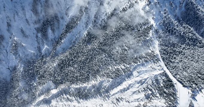 Aerial view of snow-blanketed mountains with jagged peaks and deep valleys, creating a stark contrast of light and shadow, Garmisch-Partenkirchen, Bavaria, Germany.