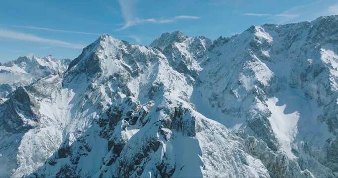 Aerial view of majestic snow-capped mountains under a clear sky, their peaks piercing the heavens, creating a breathtaking vista, Garmisch-Partenkirchen, Bavaria, Germany.