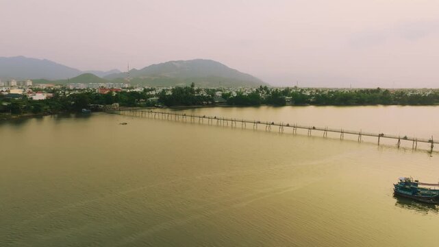 Aerial 4K of traditional Phu Kien wooden bridge crossing Cai River, Nha Trang, Vietnam
the authentic charm of rural Vietnam, highlighting the traditional engineering, peaceful tropical landscape