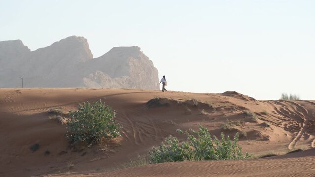 Female backpacker in Middle East desert with scenic rocky backdrop