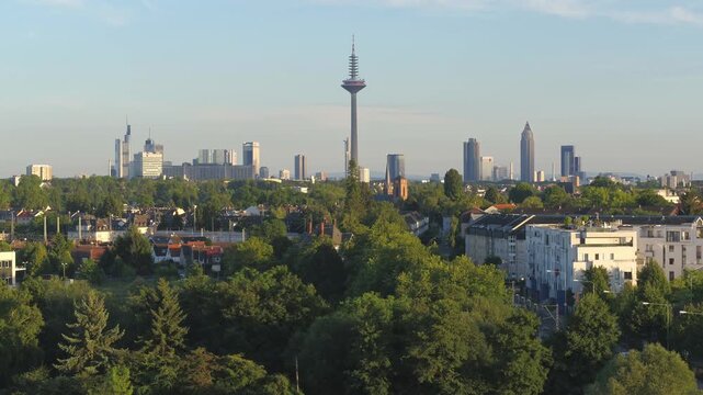 A smooth forward-moving drone shot showcasing the iconic skyline of Frankfurt am Main, Germany. The Europaturm stands prominently in the center, surrounded by famous skyscrapers like the Messeturm and