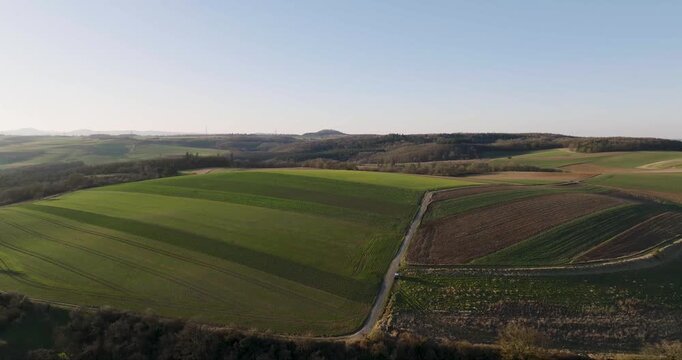 Aerial view of lush green fields and brown ploughed land, divided by a narrow path, presenting a beautiful contrast of textures, Kobern-Gondorf, Rhineland-Palatinate, Germany.