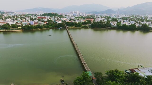 Aerial 4K of traditional Phu Kien wooden bridge crossing Cai River, Nha Trang, Vietnam
the authentic charm of rural Vietnam, highlighting the traditional engineering, peaceful tropical landscape