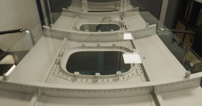 High angle view of a glass conference table featuring an aircraft fuselage section base