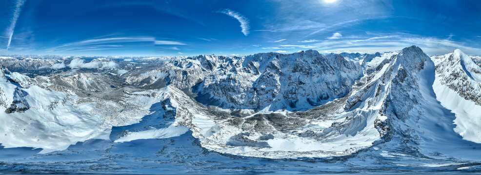 Aerial view of a majestic range of snow-capped mountains under a crisp blue sky, Garmisch-Partenkirchen, Bavaria, Germany.
