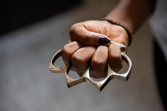Hand holding brass knuckles tightly
