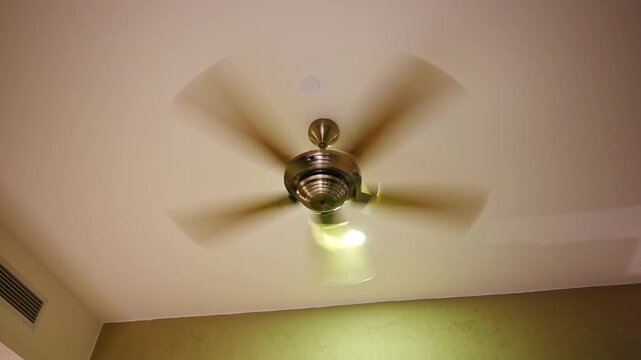 Modern Ceiling Fan Blades in Motion with Light in Interior Room
