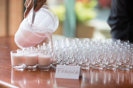 Mano che regge una caraffa e versa sorbetto tosa in bicchieri