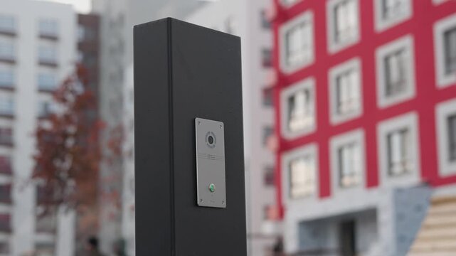 Communication and warning system on a gray pole in the courtyard of an apartment building