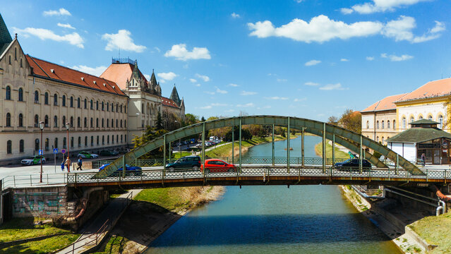 Aerial view of the bridge over the canal reflecting the azure sky, framed by the ornate architecture of Zrenjanin, Vojvodina, Serbia.