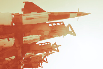 Naklejka premium Anti-aircraft cruise missiles on a launcher on blue sky background missiles are aimed to sky at day Nuclear bomb, chemical weapons, missile defense system of salvo fire Metallic missile rocket