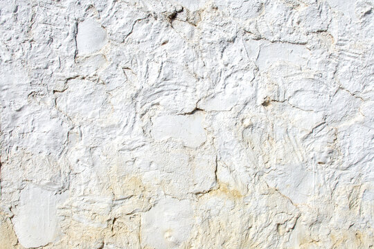 Textura de pared de estuco blanco rugoso con relieve irregular.