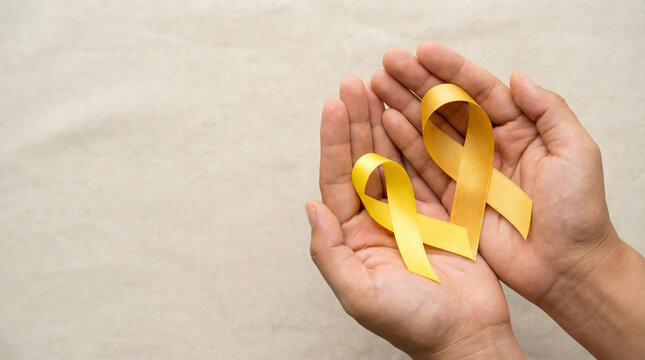 Hands holding yellow ribbon awareness symbol