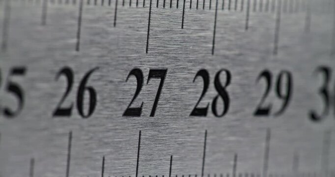 Slow Pan Over Metal Ruler. Smooth slow movement across extreme close-up of metallic ruler with black numbers and brushed surface.